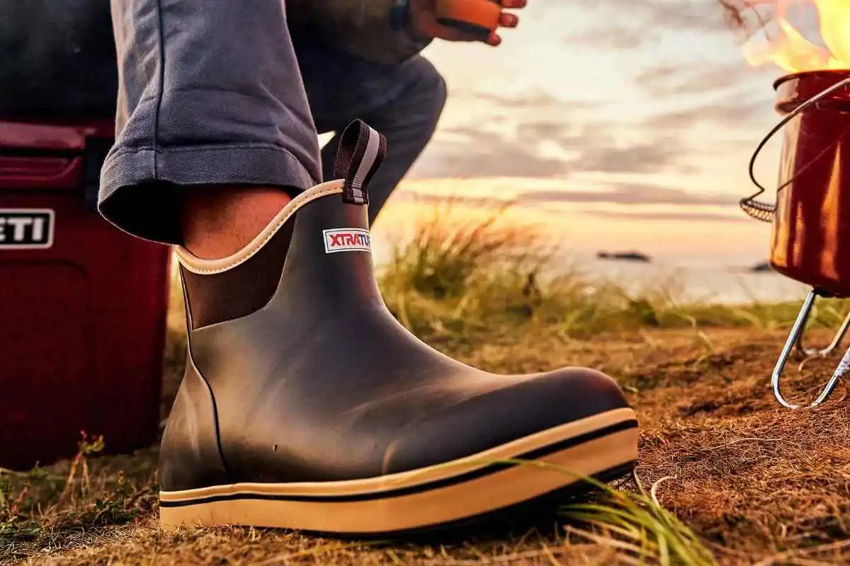 Camping with wellies next to a campfire on a beach
